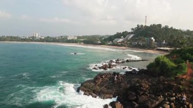Mirissa Sahili ve Papağan Kayası 'nın nefes kesici manzarası, el değmemiş turkuaz suları, altın kumlu kıyılar, kayalık kıyı oluşumları, güney Sri Lanka. Canlı tropik Hint okyanusu manzarası