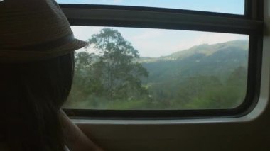 Trende özgürlüğün, seyahatin, hayat yolculuğunun, kültürlerin, manzara manzarasının tadını çıkaran neşeli bir kadın. Trendeki Kadın Sabah Yolculuğunun keyfini çıkarıyor Sri Lanka