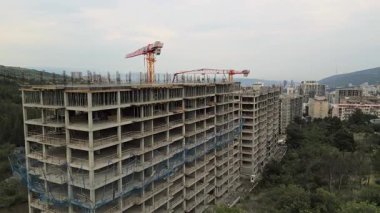 Tiflis, Gürcistan - 10 Temmuz 2024: Çatıdaki havadan bakan inşaat şantiyesi inşaatçıları yeşil bölge banliyölerinde yüksek binalar inşa ettiler