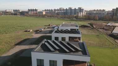 Siauliai, Litvanya, 2024: çatıdaki havadan aşağı görüşlü işçiler özel mülkiyet için güneş panelleri kurulumuna hazırlanıyorlar. Şehrin banliyölerinde yeni yeşil ev gayrimenkulleri