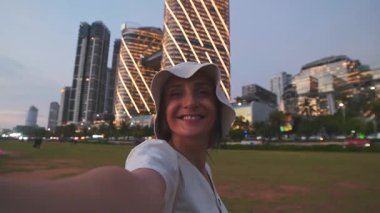 Mutlu genç kadın turist sosyal medya paylaşımı için poz veriyor Colombo 'nun başkenti Sri Lanka' da, Sunset 'te el sallıyor..