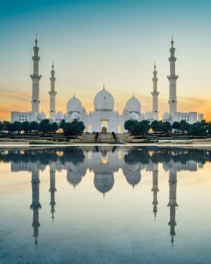 Şeyh Zayed Camii, Abu Dabi, BAE 'de, alacakaranlıkta suda yansımasıyla.