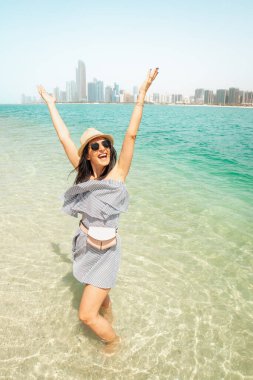 Ferahlatıcı turkuaz sularda yaşayan genç bir kadın BAE başkenti Abu Dabi 'yi ziyaret ederken iyi eğlenceler. Kıyı şeridi manzarasının tadını çıkarın.
