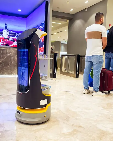 Abu Dabi, BAE - 25 Nisan 2025: Robot Abu Dabi Havaalanı Akıllı Seyahat Deneyimi 'nde Su Hizmet Ediyor. Lüks salonda misafir. Yapay zeka ve otomasyon yoluyla günlük hayatta hizmet veren kavramsal teknoloji