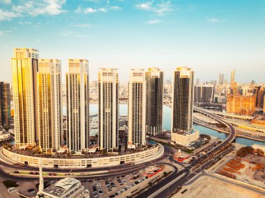 Abu Dabi, BAE - 25 Nisan 2025: Abu Dabi başkenti BAE gökyüzü açık mavi gökyüzü olan gündoğumu binaları ile gökyüzü. Business Emlak Marinası Tepeleri Uzay Sancağını Kopyaladı