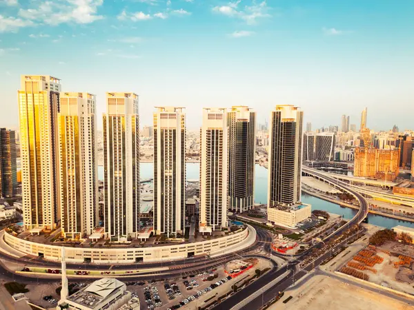 Abu Dabi, BAE - 25 Nisan 2025: Abu Dabi başkenti BAE gökyüzü açık mavi gökyüzü olan gündoğumu binaları ile gökyüzü. Business Emlak Marinası Tepeleri Uzay Sancağını Kopyaladı