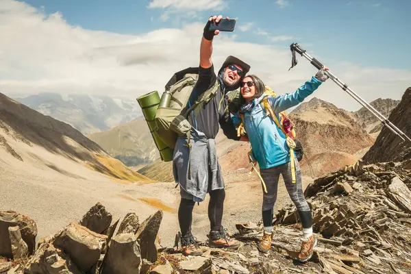 Mutlu yürüyüşçüler dağın tepesinde selfie çekiyorlar gülümseyen turistler yaz gününün tadını çıkarıyorlar sevgili ve sevgili