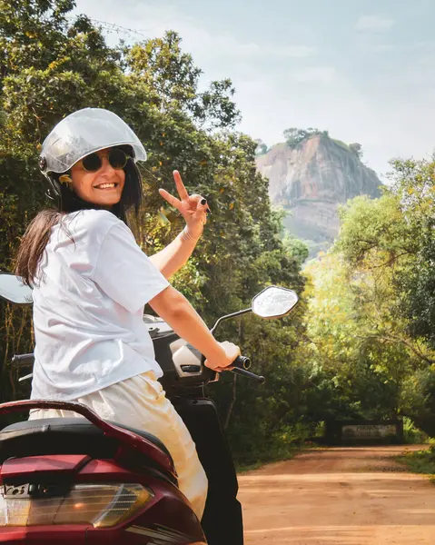 Kiralık scooter ile Pidurangala 'ya giden beyaz kadın turist pozu. Sri Lanka' da yolculuğun tadını çıkar. Asya 'daki tek başına seyahat macerası kırsal bölgeleri bağımsız olarak keşfediyor. Seyahat Sri Lanka kavramı