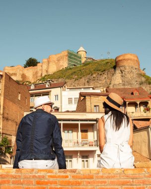 Sokak kucaklaşması yapan iki turist, Gürcistan ve Kafkasya 'da tatillerde güzel eski şehir renkli binaların keyfini çıkarıyorlar. Romantik çift yaz tatilinde birlikte kaçarlar. İnsanlar ve tatil kavramı.