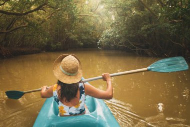 Tropikal yemyeşil orman nehrinde kano süren turist kadın Sri Lanka 'da tatilde aktif su sporları yapıyor. Doğal güzellikleri keşfetmek için aktif tatiller.