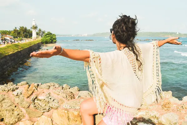 Kadın turist kollarını açmış UNESCO Galle Kalesi 'nden panoramik gözcülerin keyfini çıkarıyor. Okyanus manzaralı Galle Fort Walk konsepti. Manzara manzarası ve Sri Lanka 'da popüler bir ziyaret noktası