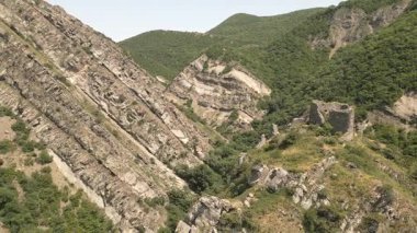 Mtskheta, Gürcistan yakınlarındaki önemli antik savunma sisteminin bir parçası olan eğimli kaya oluşumları ve orman tepeleri ile dik yamaçtaki Armazi Kalesi 'nin hava manzarası