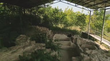 Gürcistan 'ın Mtskheta bölgesinin koruyucu çatısı altında yeşilliklerle çevrili Armaziskhevi sahasındaki eski kraliyet hamamı kalıntıları üzerinden yürüme bakış açısı