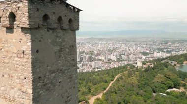 Gökyüzü panoramik manzarası Turtle Gölü 'nün üzerindeki antik Svan savunma kulesi, Vake ilçesi ve Tiflis silueti üzerindeki kentsel büyüme, Georgias mimari evrimini sembolize ediyor..