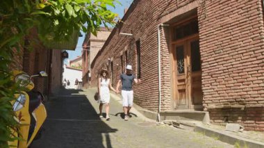 Tiflis, Gürcistan - 27 Mayıs 2025: Tatilde eski Tiflis caddesini gezen birkaç turist - tatilde birlikte gülen mutlu arkadaşlar - insanlar ve tatil kavramı. Gürcistan 'da seyahat