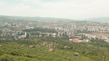 Hava panoramik manzarası Tiflis ufuk çizgisi ve Kaplumbağa Gölü üzerindeki antik Svan taş kulesi, Kafkas savunma mirasını, geleneksel mimariyi ve tarihi muhafazayı sembolize ediyor.