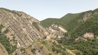 Mtskheta, Gürcistan yakınlarındaki önemli antik savunma sisteminin bir parçası olan eğimli kaya oluşumları ve orman tepeleri ile dik yamaçtaki Armazi Kalesi 'nin hava manzarası