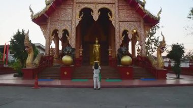 Chiang Rai, Tayland - 2023 Kadın ziyaretçi fotoğrafı Wat Chiang Yuen Kızıl Tapınağı Chiang Rai Tayland. Zengin dekore edilmiş Budist türbesi naga yılanları, altın Buda, karmaşık mimari