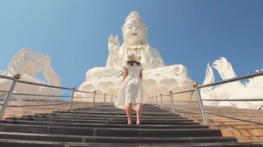 Wat Huay Pla Kang Chiang Tayland 'daki beyaz ejderha merdiveninin yanında yürüyen turist kadın. Budist ruhani konumu, seyahat deneyimi, kültürel turizm, ruhsal yolculuk, dini mimari