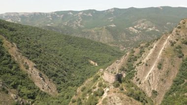 Mtskheta, Gürcistan yakınlarındaki önemli antik savunma sisteminin bir parçası olan eğimli kaya oluşumları ve orman tepeleri ile dik yamaçtaki Armazi Kalesi 'nin hava manzarası