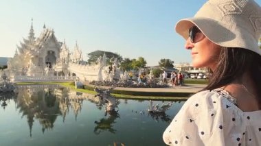 Chiang Rai, Tayland - 2024: Turist kadın gezgin Wat Rong Khun Beyaz Tapınak Chiang Rai Tayland 'ı gezerken beyaz elbiseler giyer. Seyahat blogcusu turistik ilgi odağı