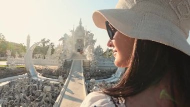 Chiang Rai, Tayland - 2024: Turist kadın gezgin Wat Rong Khun Beyaz Tapınak Chiang Rai Tayland 'ı gezerken beyaz elbiseler giyer. Seyahat blogcusu turistik ilgi odağı