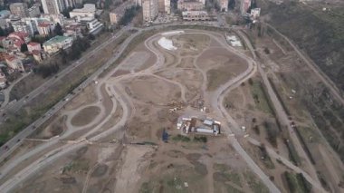 Panorama Tiflis Central Park 'ın üzerinde uçarak Saburtalo ilçesinin ufuk çizgisini çevreleyen gökyüzü modern gayrimenkul genişlemesi ve kentsel planlama gösteriyor.