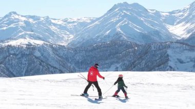 Mestia, Gürcistan - 11 Ocak 2025: Gürcü erkek kayak hocası kayak dersi veriyor. Profesyonel kayak rehberliği, kış sporları eğitimi, eski teknik, çocukluk gelişimi