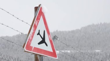 Karlı kış koşullarında uçak uyarı işareti, havacılık güvenliğini, uzaktan kumandalı uçak pistini, sert iklimi, izole yolculuğu, risk farkındalığını, tehlike uyarısını, aşırı çevreyi simgeliyor.
