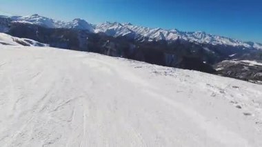Tetnuldi kayak merkezinde yüksek hızda kayak yapan POV kayakçısı... Kafkasya dağlarıyla kaplı, karla kaplı yamaçlarda yokuş aşağı bir yolculuk. Güneşli kış günü, Svaneti harikalar diyarı. Messi. Georgia.