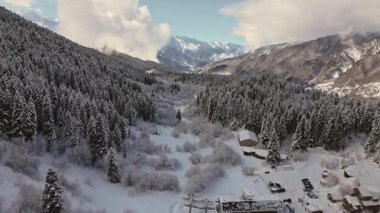 Gürcistan 'ın Mestia kentindeki kayak merkezinin yakınındaki çam ormanı ve ahşap kulübe üzerindeki hava dinamik hiperhız düşüşü. Karlı Alp Vadisi manzarası, panoramik Kafkasya dağları olan huzur dolu vahşi doğa.