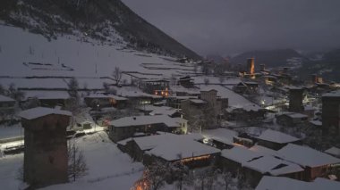 Hava aracı kar, günbatımından sonra Mestia köyünü kapladı. Parlayan Svan kuleleri, geleneksel mimari ve alacakaranlık gökyüzünün altındaki dağ zirveleri. Popüler kayak tatil beldesi Avrupa