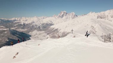 Açık mavi gökyüzü altında Freeriders açık hava manzarası, ekstrem kış sporları, macera, risk, taşra keşfi, doğa gücü, takım çalışması, dayanıklılık, alp özgürlüğü sembolize