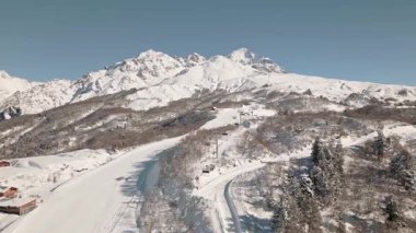 Gürcistan 'ın Svaneti bölgesindeki Tetnuldi kayak merkezinin hava manzarasında kışlık yamaçlar, gondollar ve görkemli Kafkasya dağ manzaraları görülüyor. Popüler kış kayağı tatil beldesi Avrasya