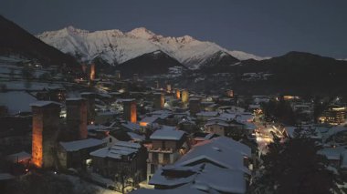 Günbatımından sonra Mestia köyünü kaplayan statik hava manzaralı kar parlayan Svan kuleleri, geleneksel mimari ve alacakaranlık gökyüzünün altındaki dağ zirveleri. Popüler kayak tatil beldesi Avrupa