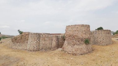Gürcistan 'da tarihi miras ve kültür turizmini sembolize eden yeşillik ve kentsel manzarayla çevrili antik Rustavi Kalesi' nin havadan yakından görünüşü göl kenarındaki duvarları yıkıyor
