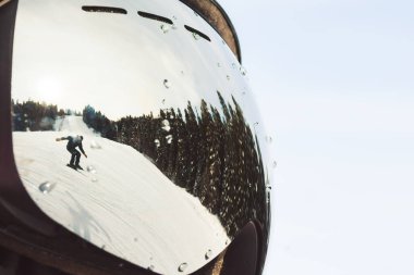 Karlı yamaçları oyan snowboardcu su damlaları ile kayak gözlüklerine, açık kış gökyüzü altında çam ormanlarına yansıyan ekstrem spor, güvenlik, perspektif.