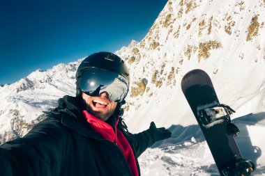 Mutlu snowboardcu, Kafkasya dağlarında kışı geçirmeden önce zirveye ulaştıktan sonra selfie çekiyor.