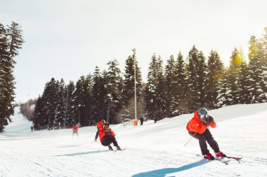 Gürcistan, Svaneti - 15 Şubat 2025: hastvali kayak merkezinde kayak kurtarma ekibi kırmızı ceketli kask takarak kayak yapıyor.