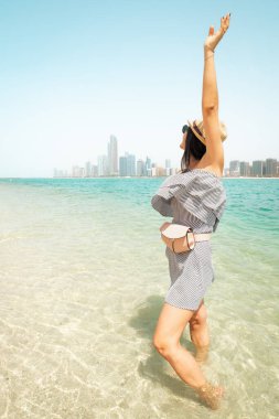 Ferahlatıcı turkuaz sularda yaşayan genç bir kadın BAE başkenti Abu Dabi 'yi ziyaret ederken iyi eğlenceler. Kıyı şeridi manzarasının tadını çıkarın.