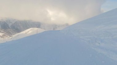 Tetnuldi kayak merkezinde yüksek hızda kayak yapan POV kayakçısı... Kafkasya dağlarıyla kaplı, karla kaplı yamaçlarda yokuş aşağı bir yolculuk. Güneşli kış günü, Svaneti harikalar diyarı. Messi. Georgia.