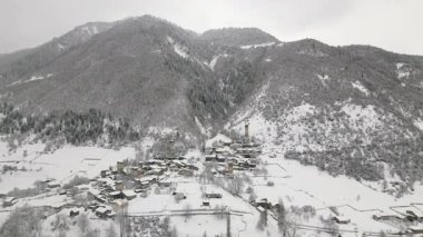 Laghami 'nin Mestia Gürcistan' daki insansız hava aracı anteninde karla kaplı ortaçağ Svan savunma kuleleri ve taş evler, Kafkasya dağ vadisi, miras, turizm