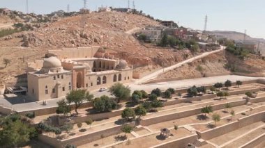 Mardin 'deki Kasimiye Madrasa' nın üzerinde kubbeleri, avlusu ve parlak güneş ışığı altındaki kayalık tepeleri çevreleyen hava uçuşları. 4k kalite görüntü