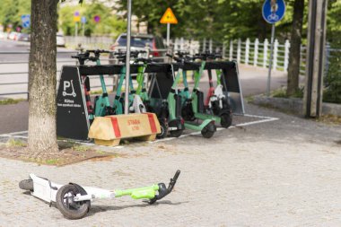 Düşen elektrikli scooter, bu scooterların bırakıldığı yerin önünde kiralanmış. Helsinki, Finlandiya.