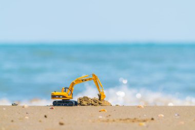 Kumlu deniz kıyısında tırtıl model kazıcı