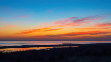 Deniz kıyısında parlak renkli gün doğumu