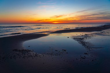 Deniz kıyısında parlak renkli gün doğumu