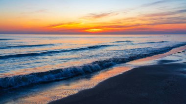 Deniz kıyısında parlak renkli gün doğumu