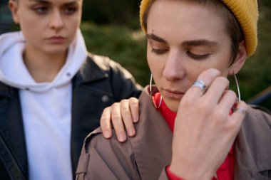 Cropped photo of female lgbt couple, in a quarrel, one friend comfortingly put her other hand on the shoulder clipart