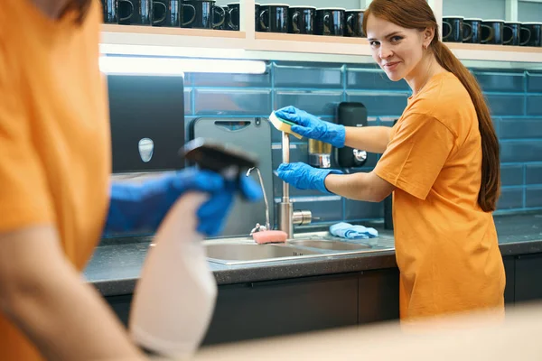 年轻的女清洁员在厨房里清洁和消毒表面 她们用喷雾器 海绵和餐巾 — 图库照片